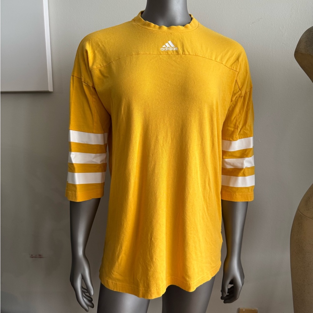 Yellow Adidas top with sleeve stripes.